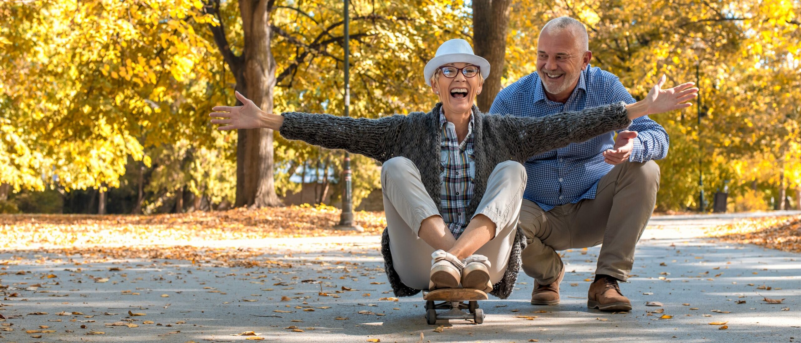 An elderly couple with a woman sitting on skate in the park